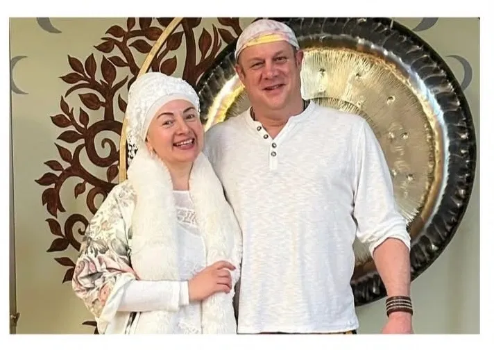 Couple smiling in front of a gong